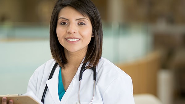 A doctor wearing a white lab coat with a stethoscope around her neck.