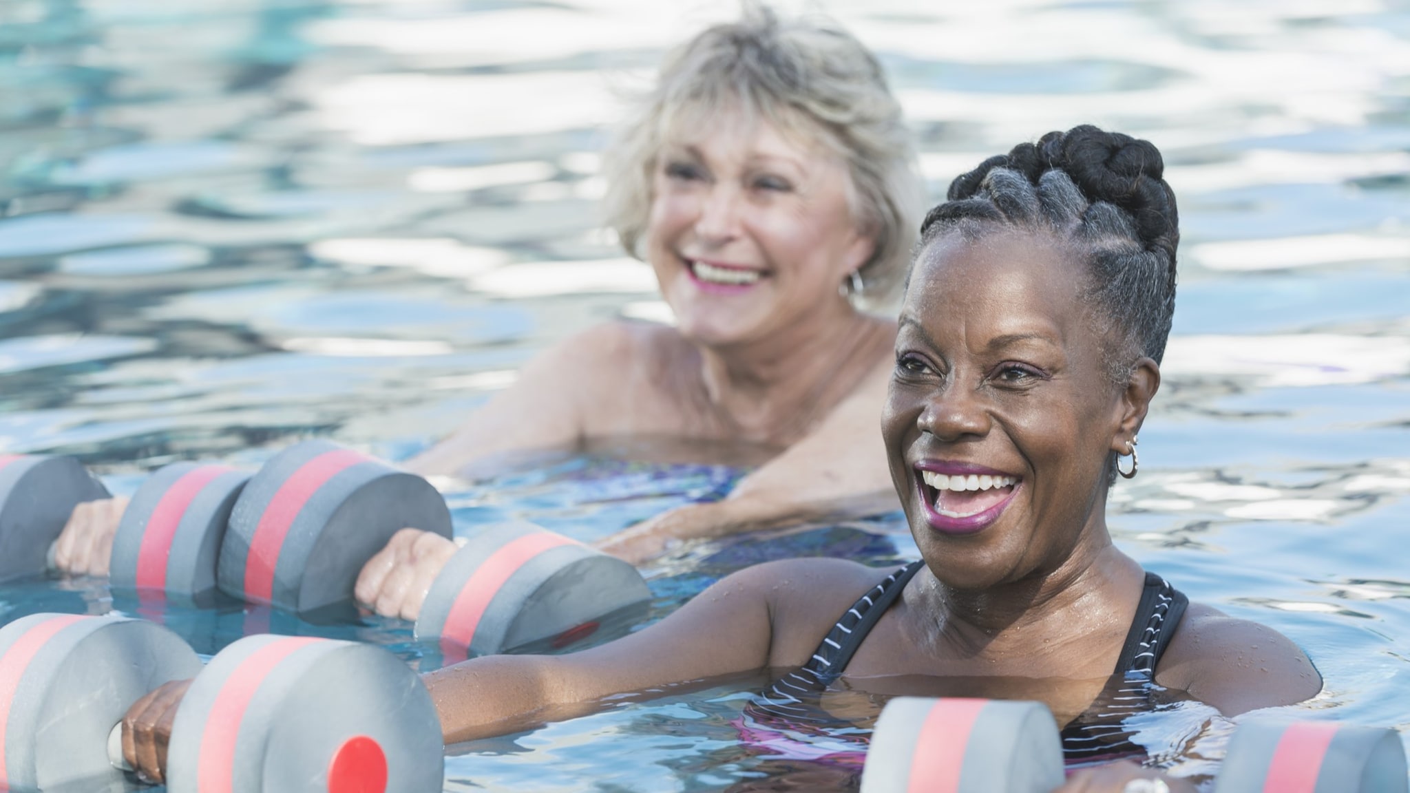 Senior black woman and friend doing water aerobics
