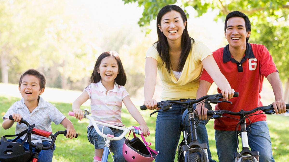 Asian family of four riding bikes.